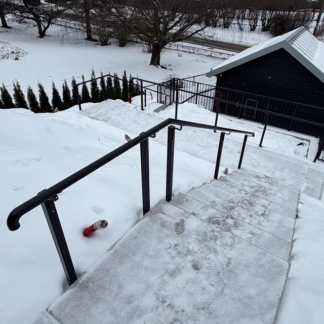 Sort rekkverk ved betongtrapp