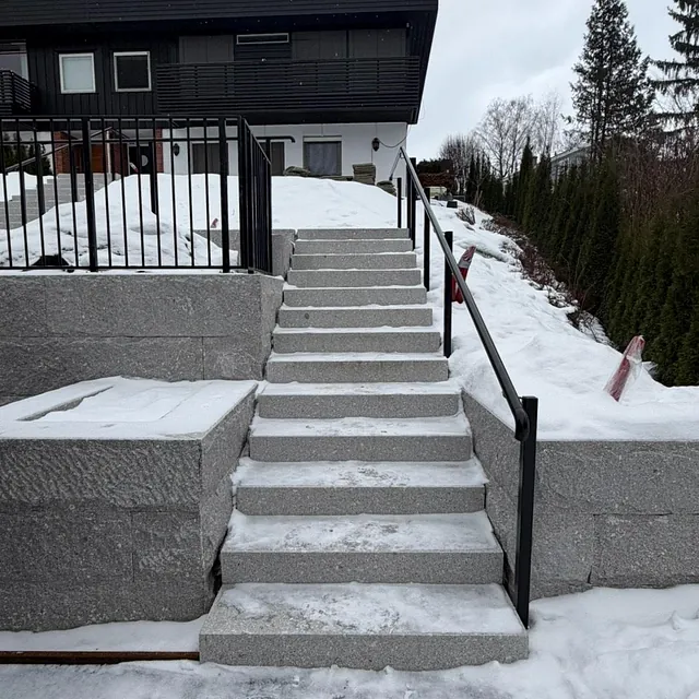 Betongtrapp med sort rekkverk med spiler